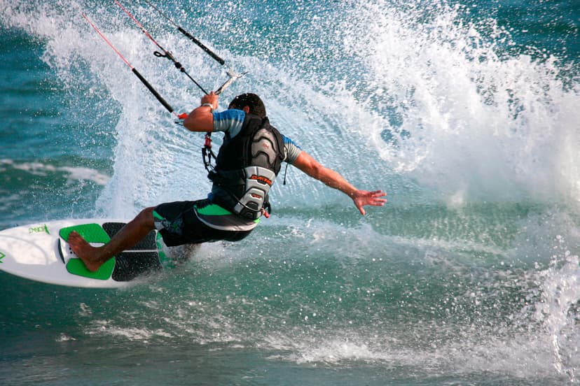 Alumno de Fredoom Kite School saltando una ola en Estepona practicando kitesurf