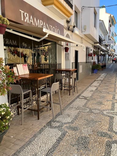 Fachada de Trampantojo con mesas altas en la calle