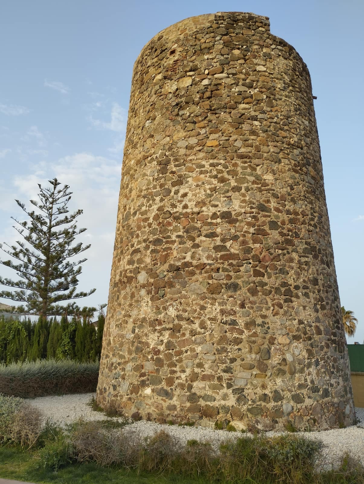 Torre almenara del Saladillo, de planta circular y mampostería de cantos rodados, con la luz de la tarde
