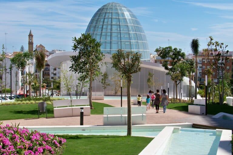 Cúpula acristalada del Parque Botánico Orquidario de Estepona y la plaza ajardinada que lo rodea