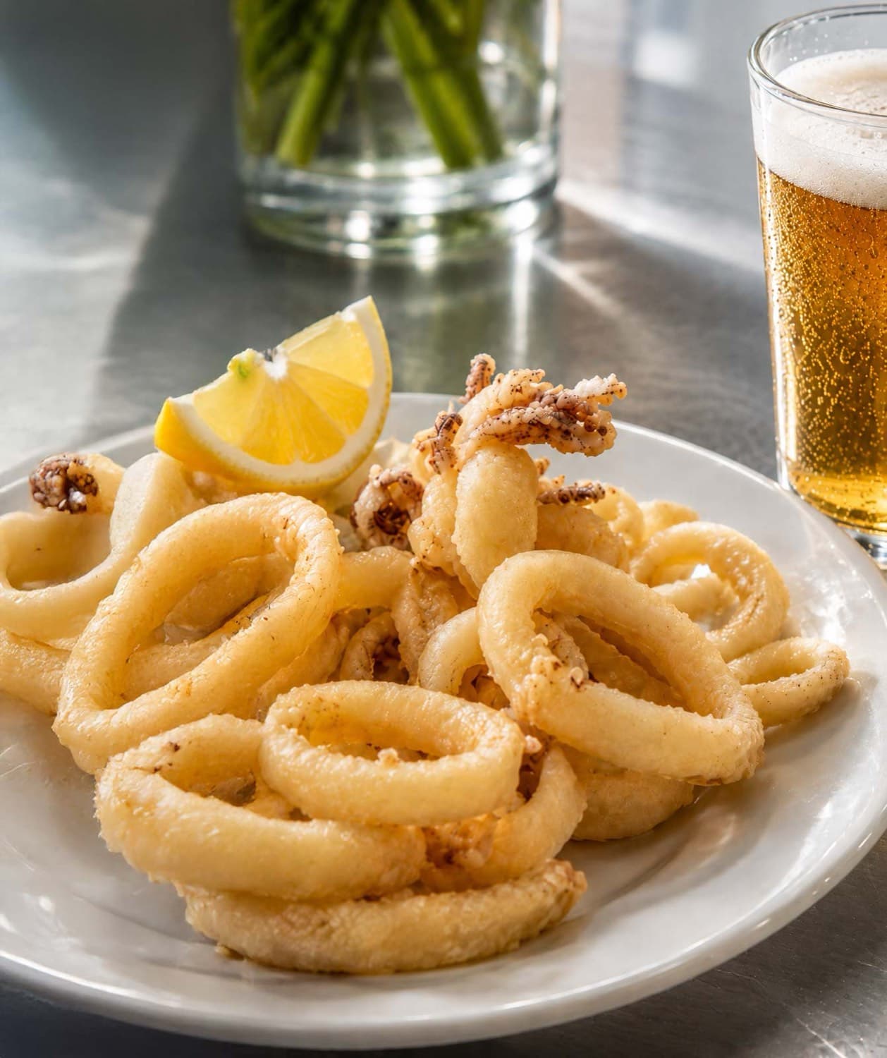 Ración de calamares fritos con limón y una caña en el Restaurante La Palma