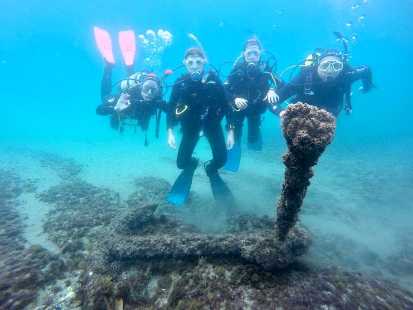 Grupo de buceadores junto a un ancla antigua en el fondo marino de Estepona