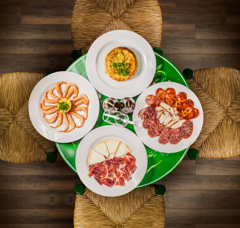 Selección de tapas -- gambas, jamón, queso y embutido -- servidas en Mi Caseta, Estepona
