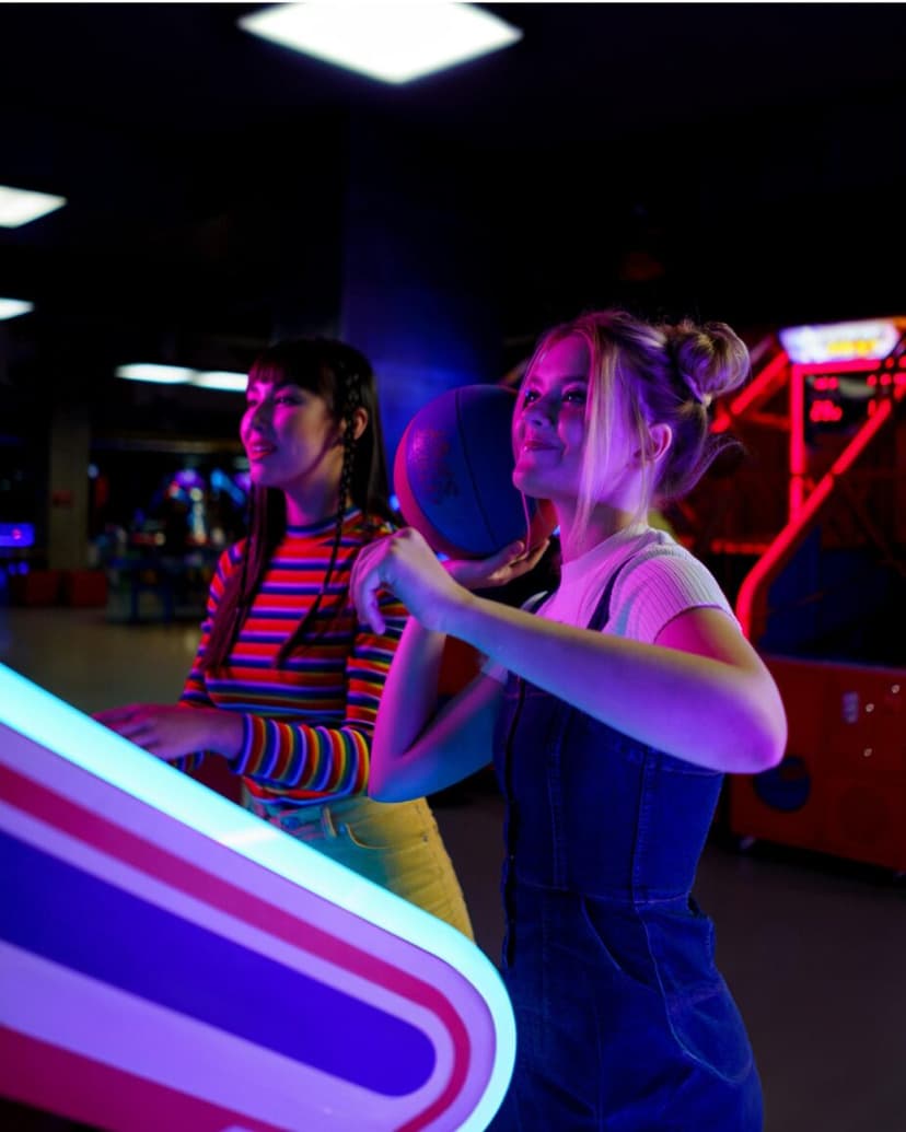 Dos amigas jugando a una máquina arcade de baloncesto en Miroko Park