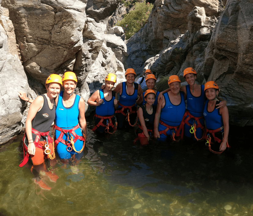 Familia con arnés y casco de barranquismo dentro de una poza de agua en Estepona