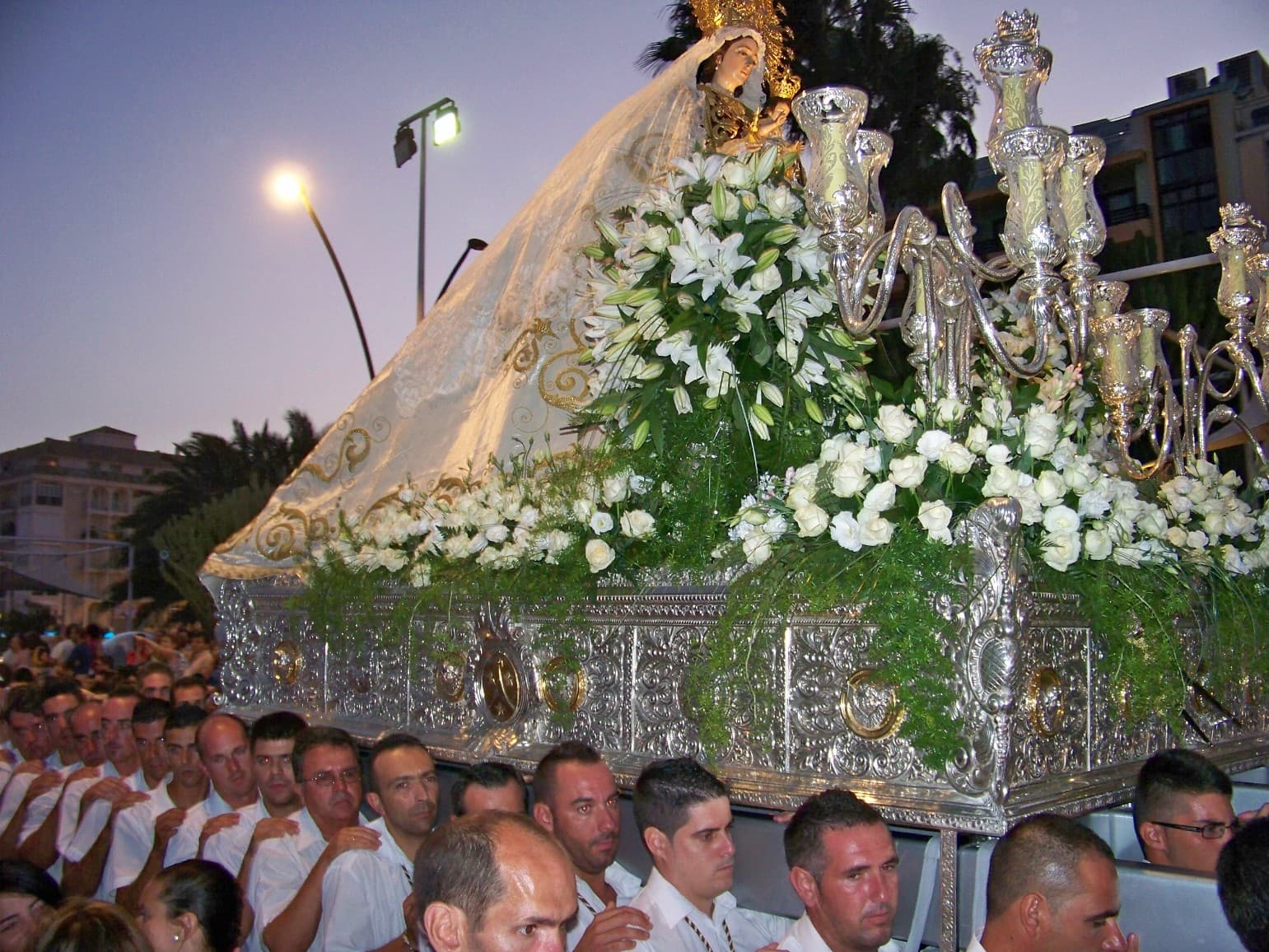 Portadores de la Virgen del Carmen entrando al mar durante la procesión marítima en Estepona