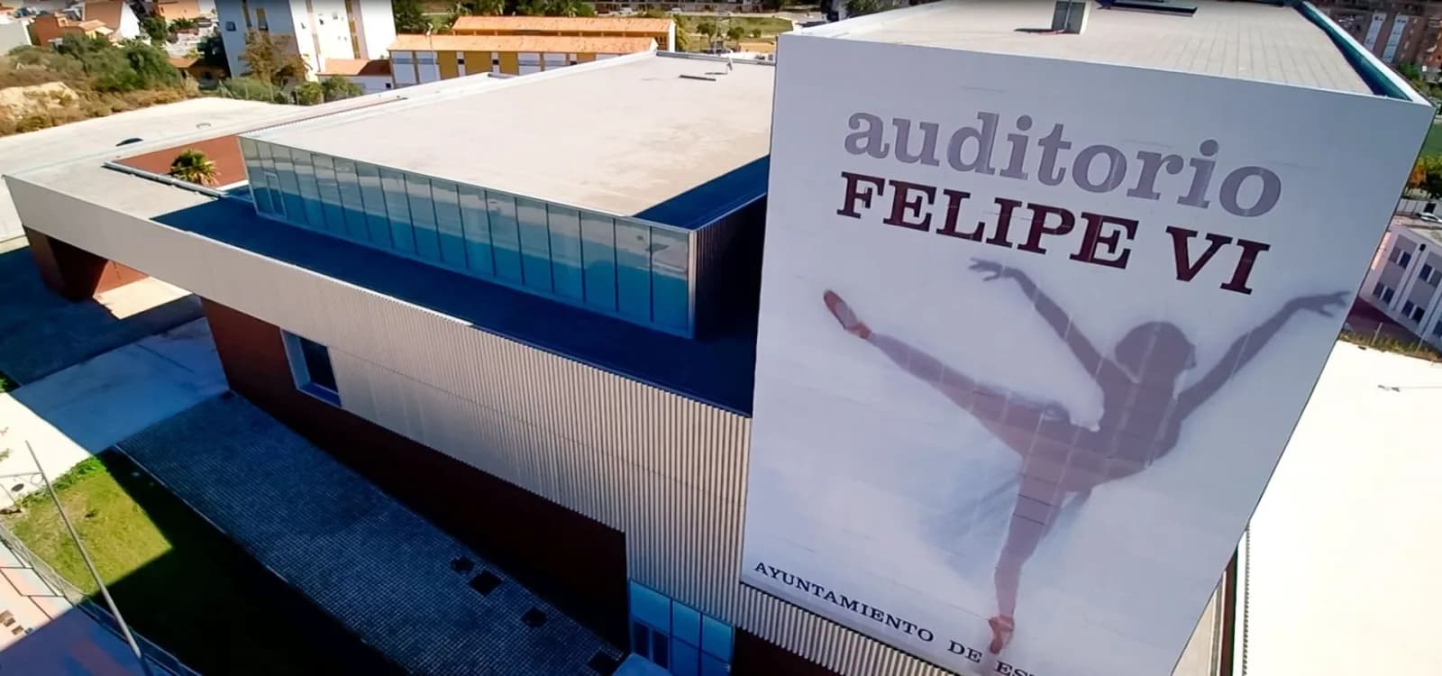 Luftaufnahme des Teatro Auditorio Felipe VI in Estepona mit seiner großen weißen Fassade und der Silhouette einer Tänzerin