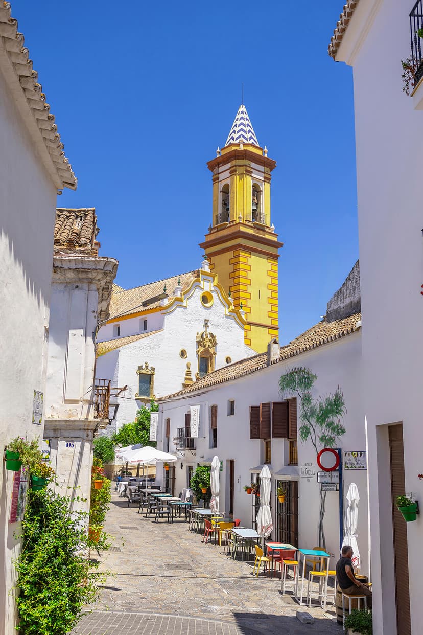 Calle del casco de Estepona con el campanario de la iglesia Los Remedios al fondo.